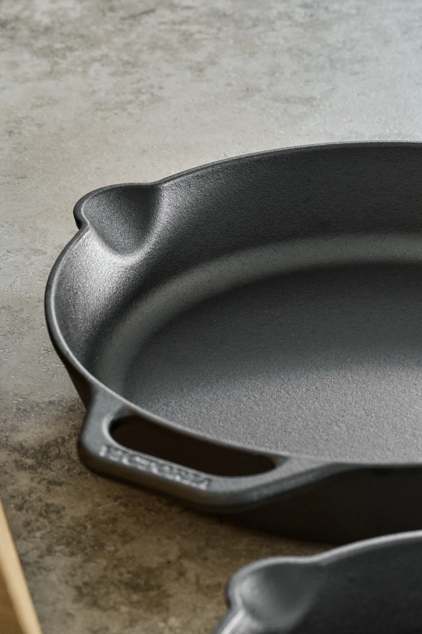 Lähikuva valurautapannusta, jossa on kaatonokka ja kahva. 