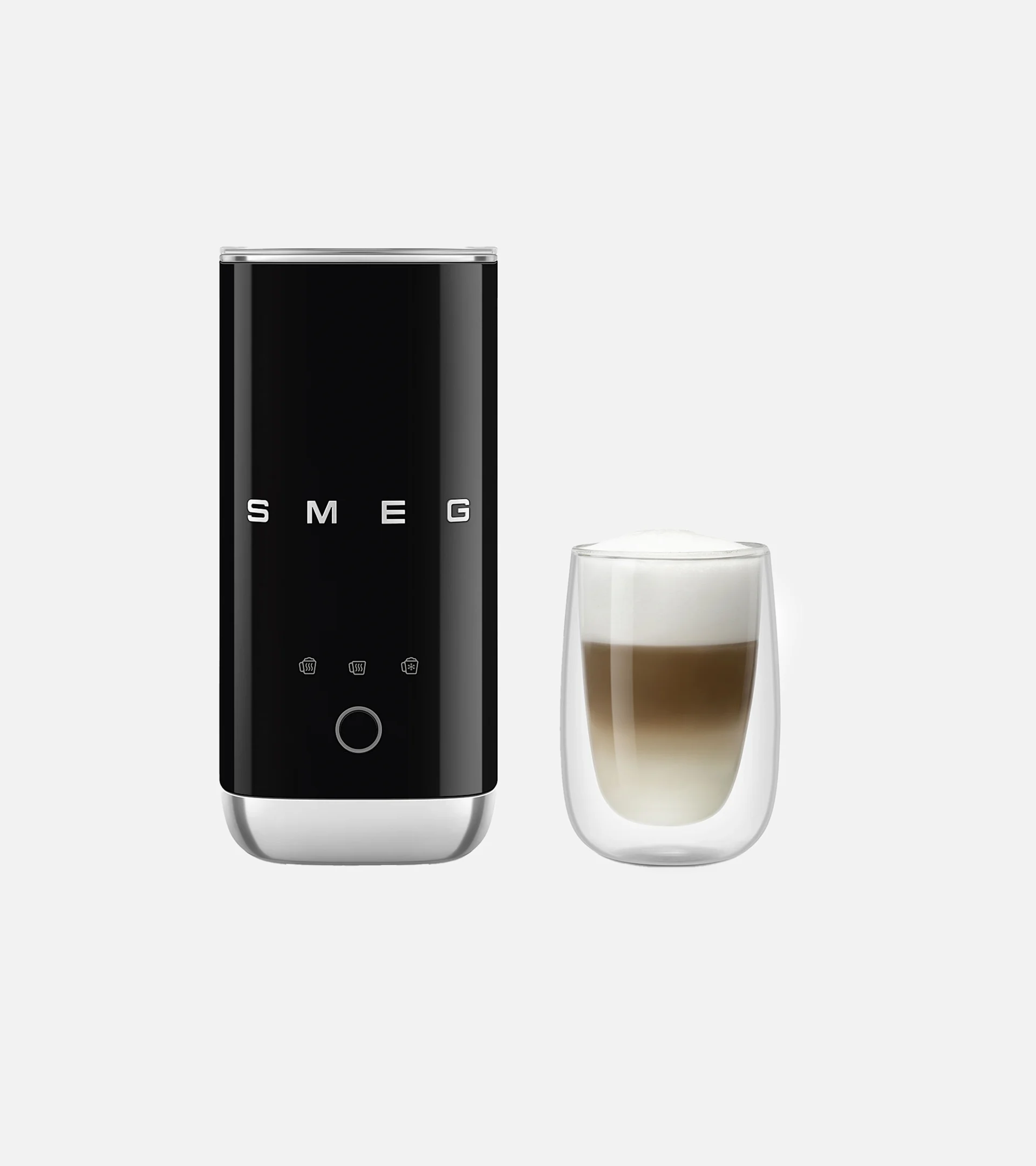Musta Smeg maidonvaahdotin kerrostetun kahvin lasin vieressä, jossa on vaahtoa.