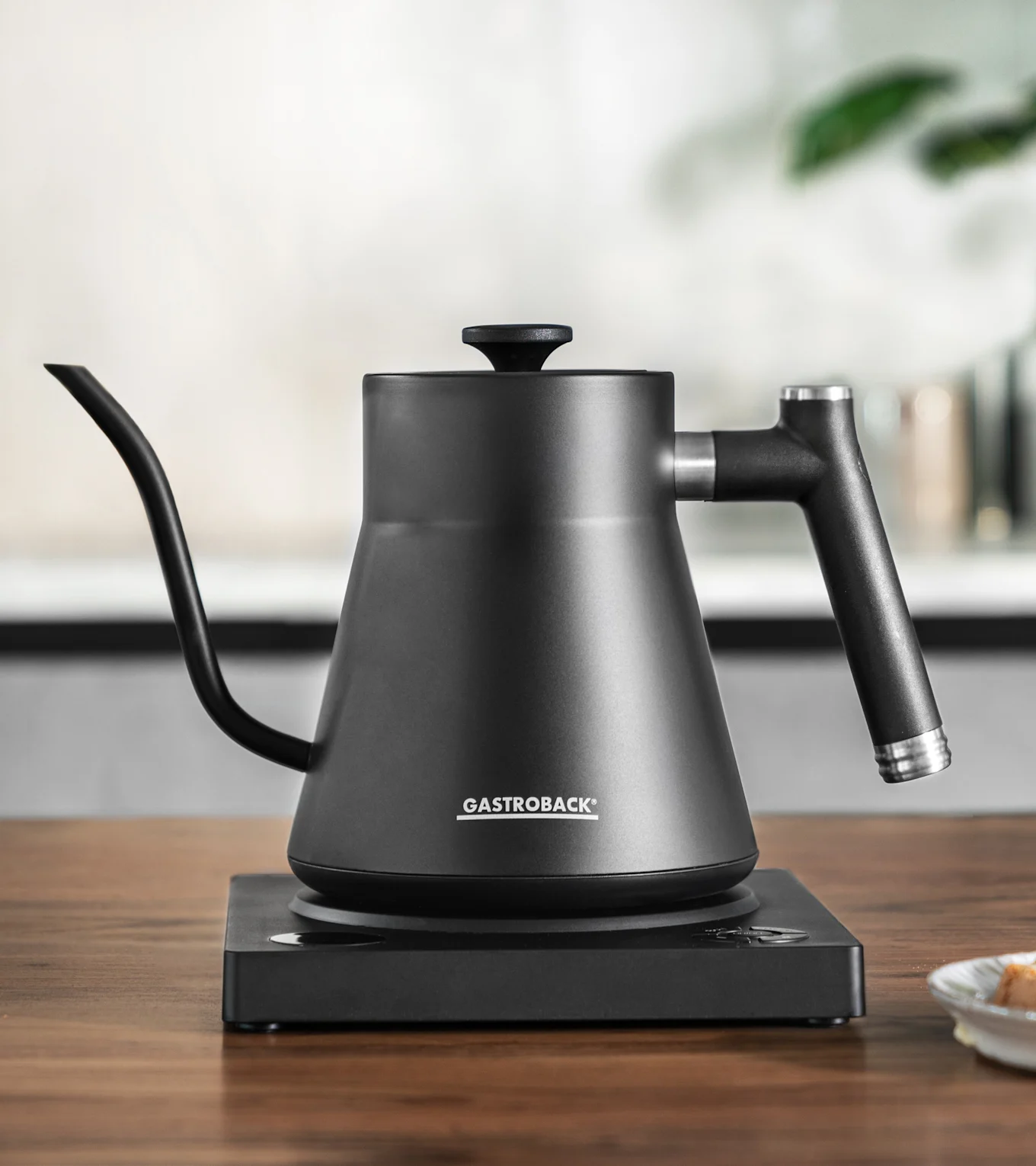 Mattamusta pour-over-vedenkeitin hanhenkaulaputkella ja yhteensopivalla sähköjalustalla.