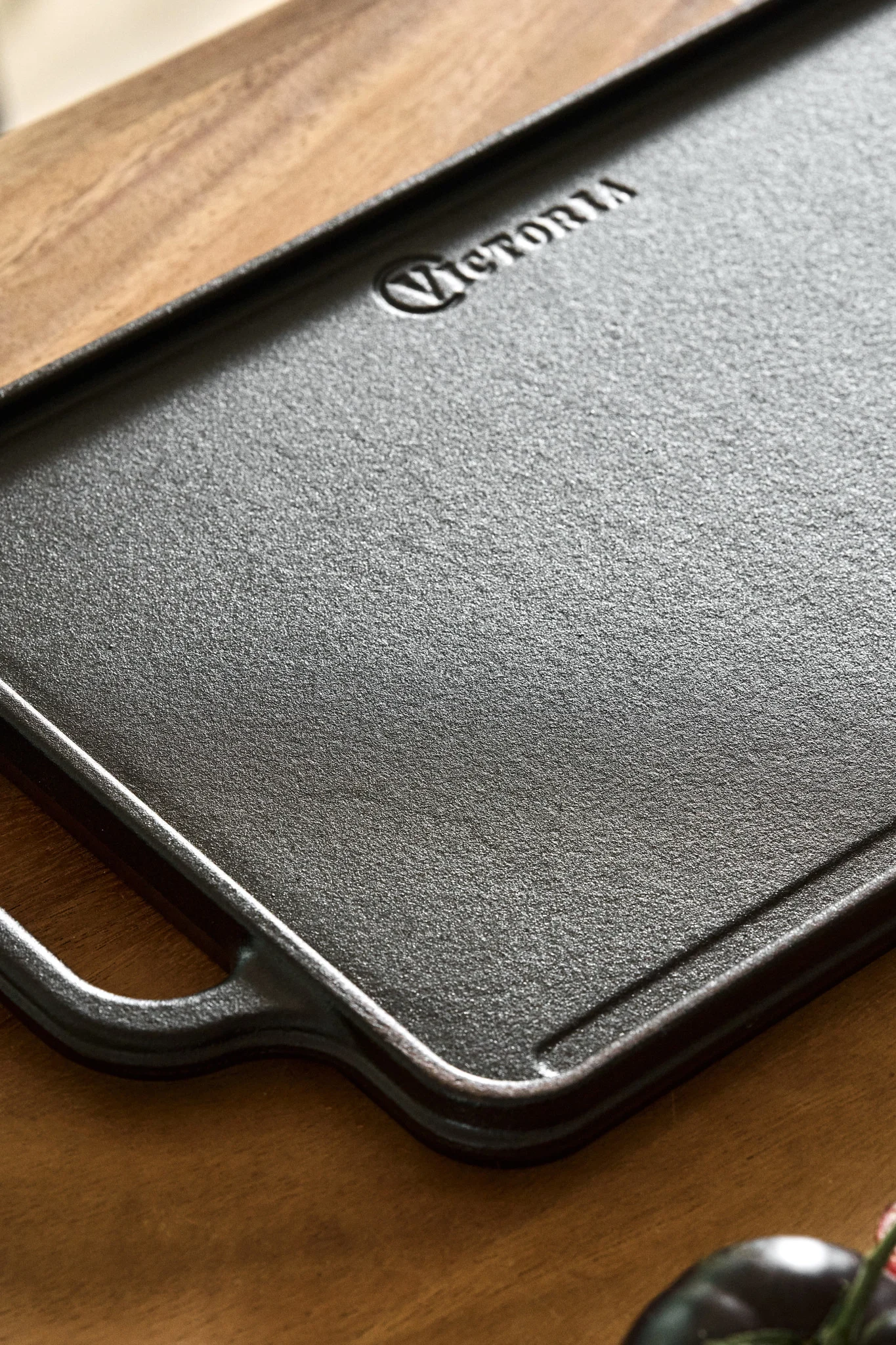 Käännettävä valurautalevy puisen keittiön työtason päällä. 